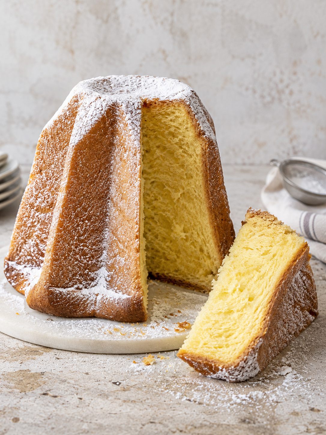 Pandoro spolverato di zucchero a velo, con una fetta tagliata